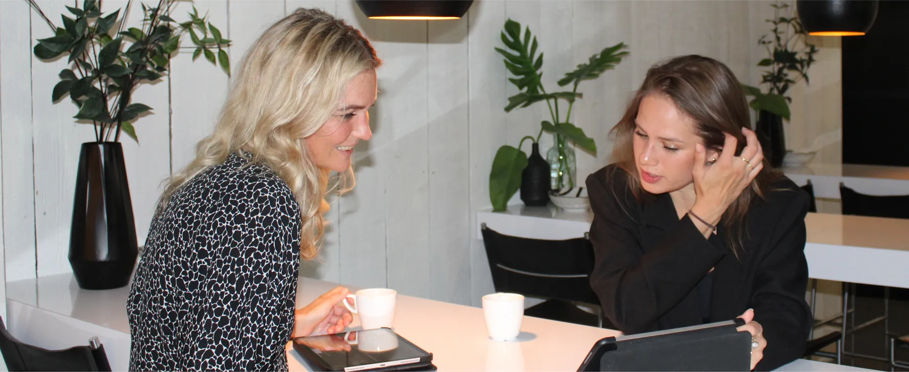 Lenneke en Demi samen aan tafel op kantoor